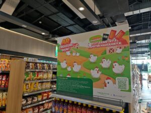 Bright promotional display in a supermarket with cartoon chickens and a banner reading 'AR Treasure Hunt' for a game-based promotion, set among shelves of snacks and groceries.