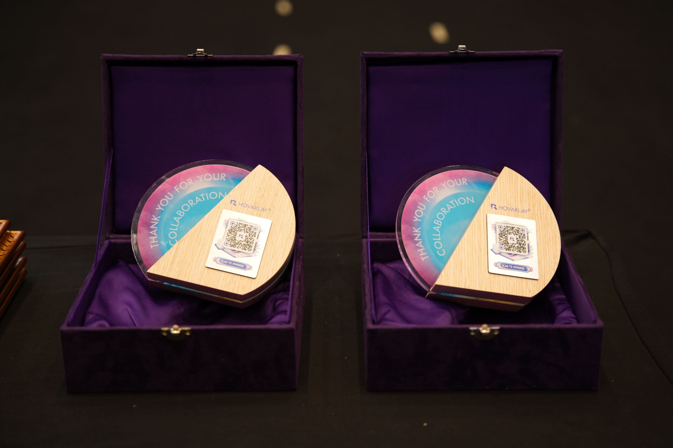 Two purple presentation boxes open to reveal round gradient plaques that say 'THANK YOU FOR YOUR COLLABORATION' with QR code cards inside.